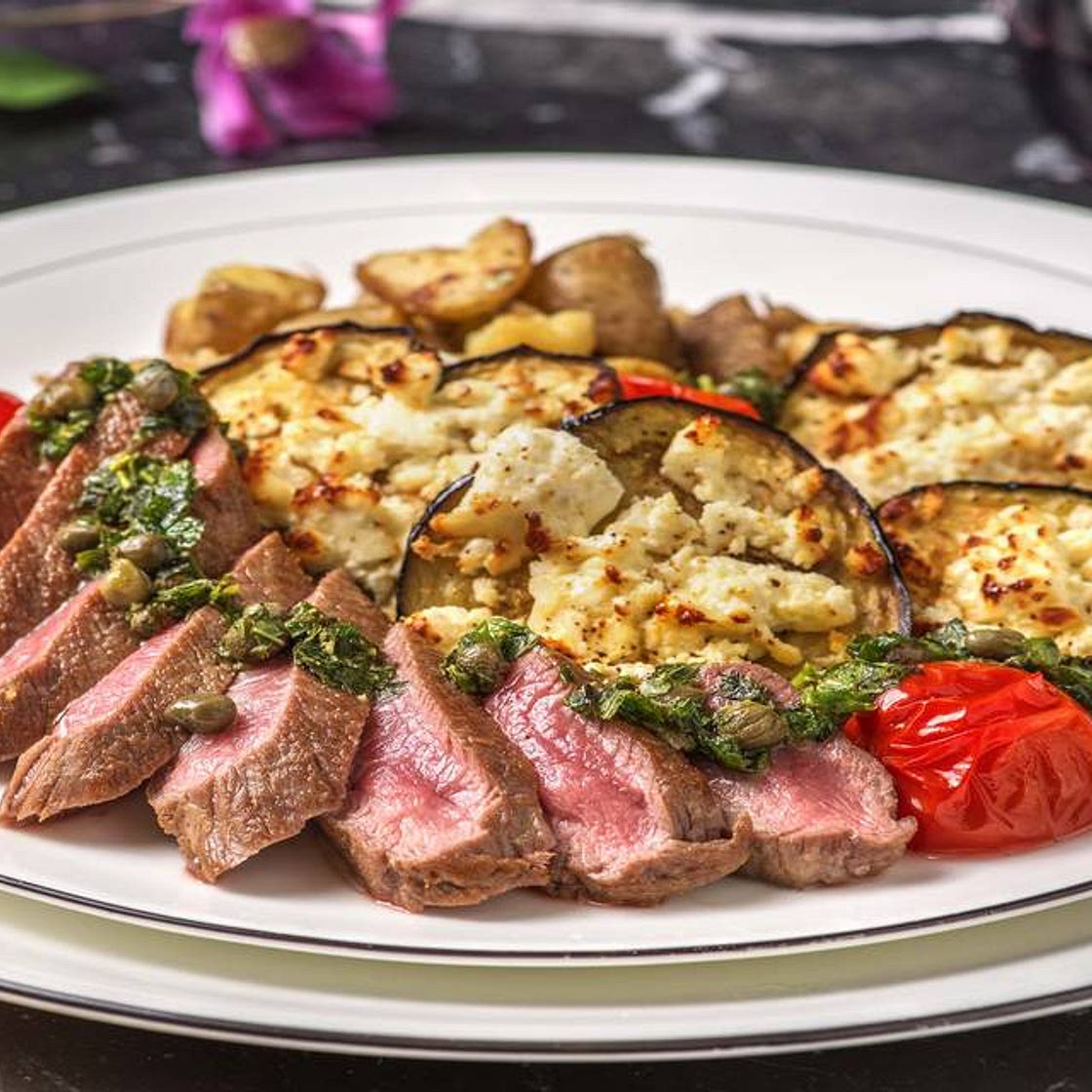Mediterranean Lamb Loin with Garlicky Crushed Potatoes with Feta Roasted Aubergine, Roasted Tomatoes and Salsa Verde