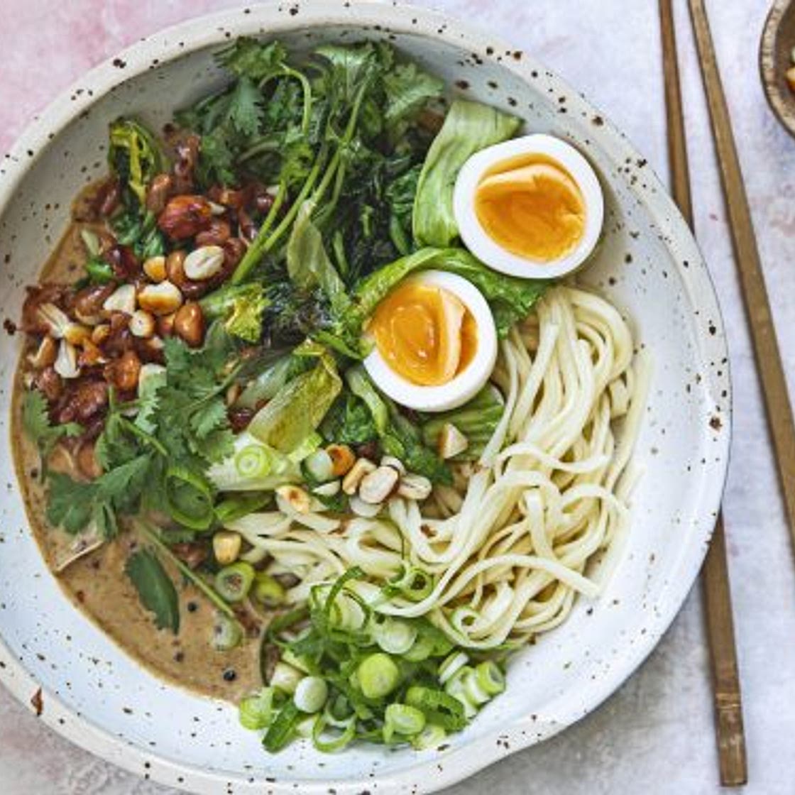 noedels met gewokte andijvie, tahin-sojasaus en pinda’s