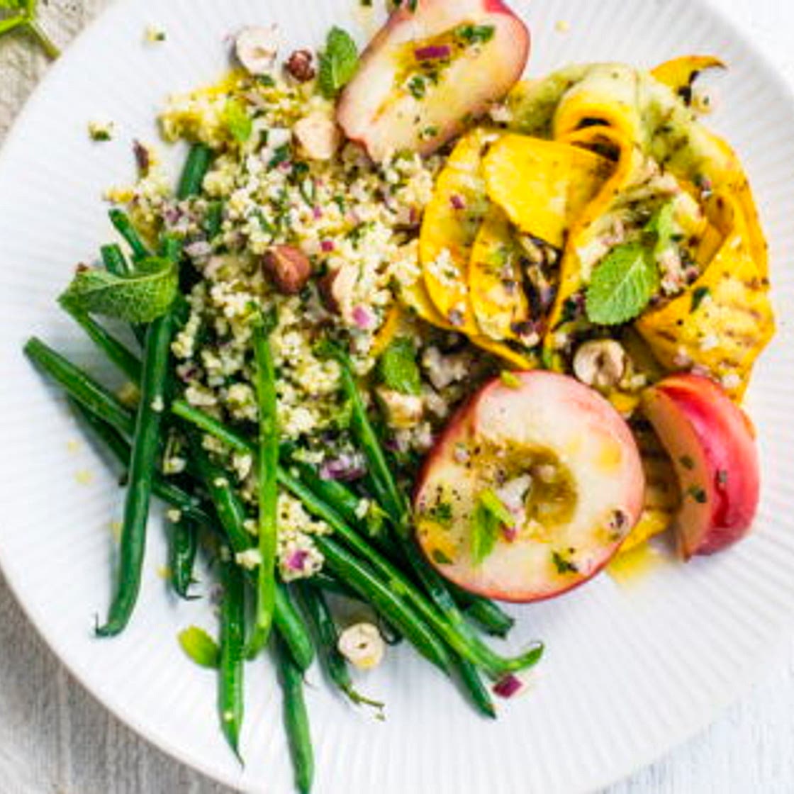 Assiette végétarienne, millet, haricots verts, courgettes jaunes et pêches