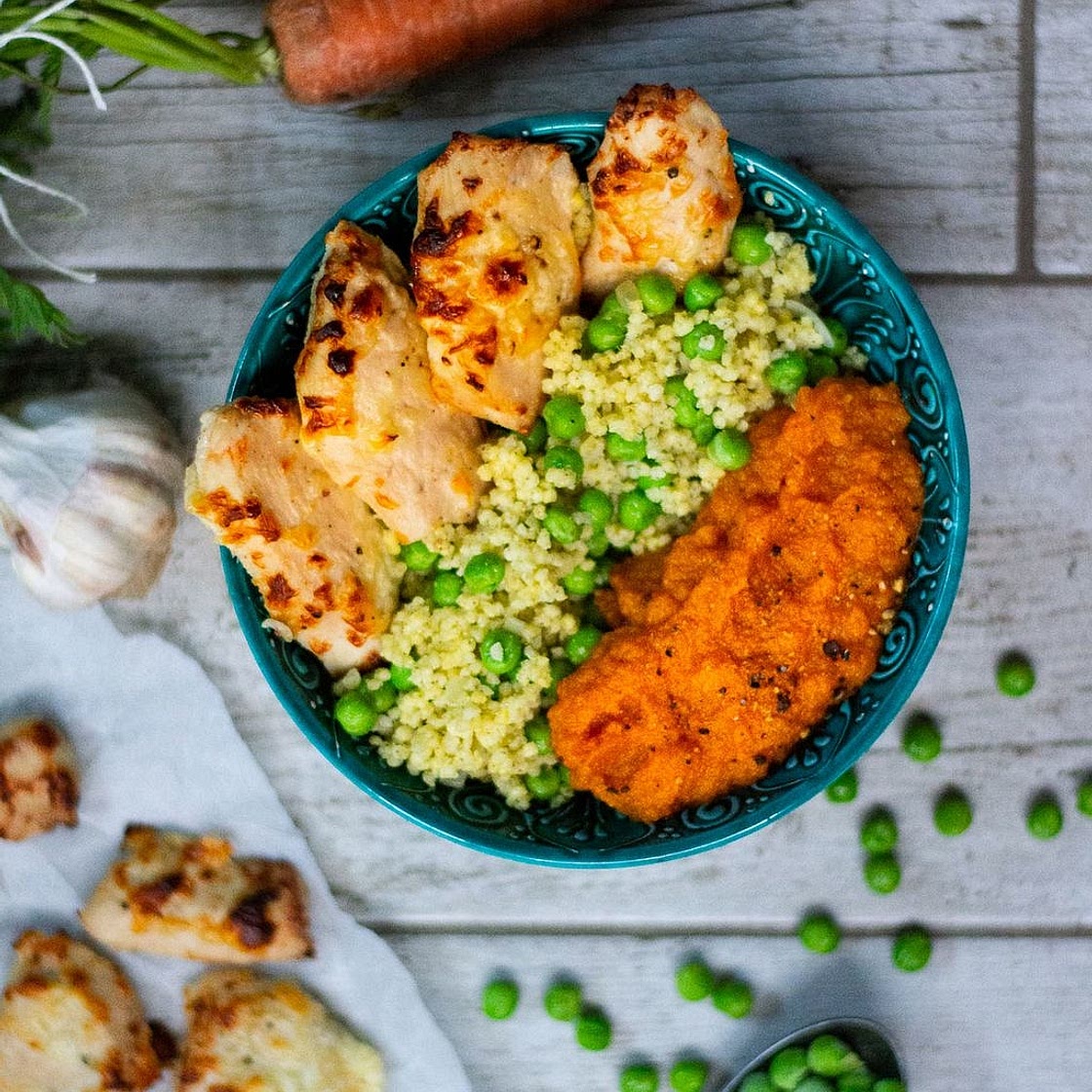 Roasted chicken pieces in yogurt marinade with millet porridge, peas, and carrot purée