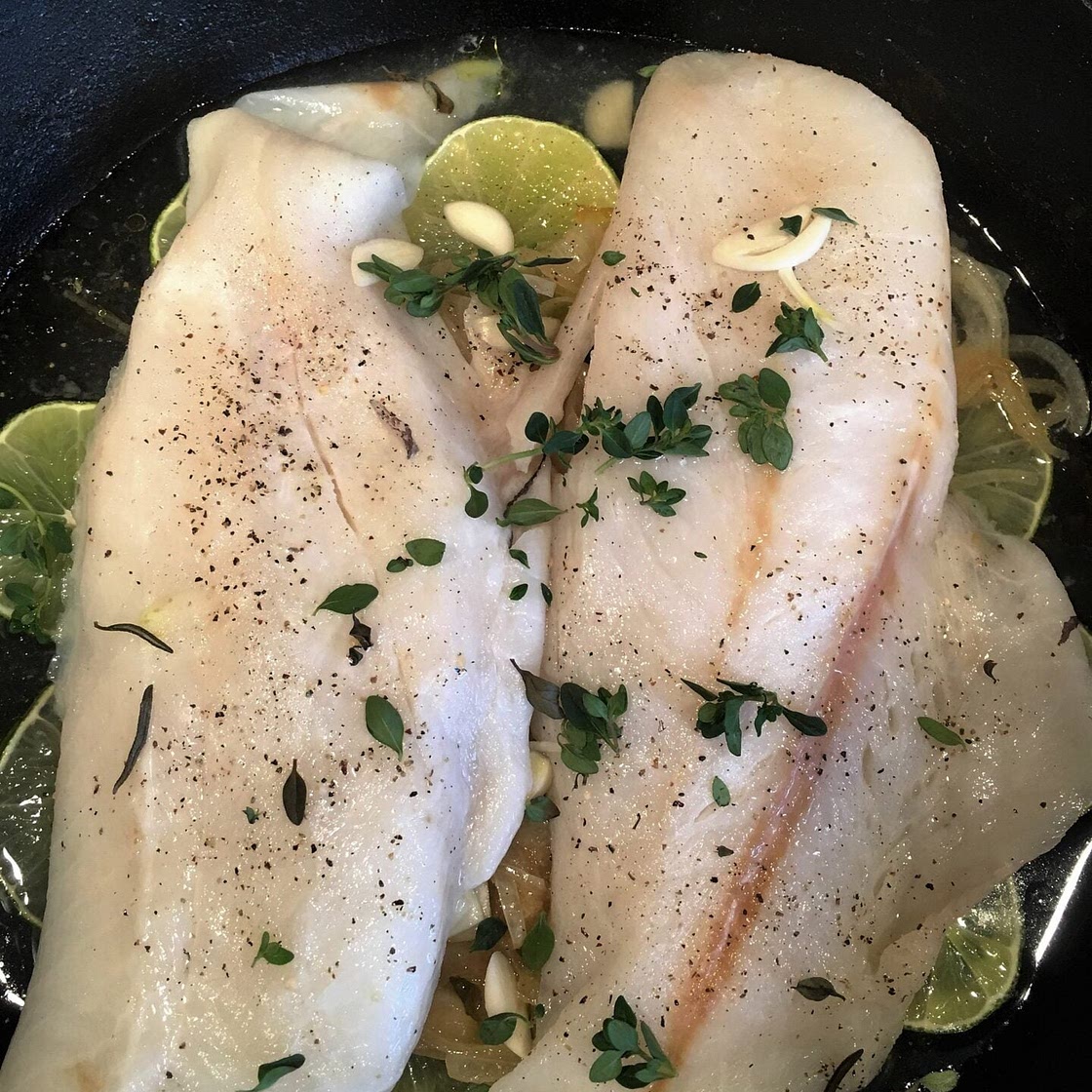 Dover sole with caramelized onions in a skillet