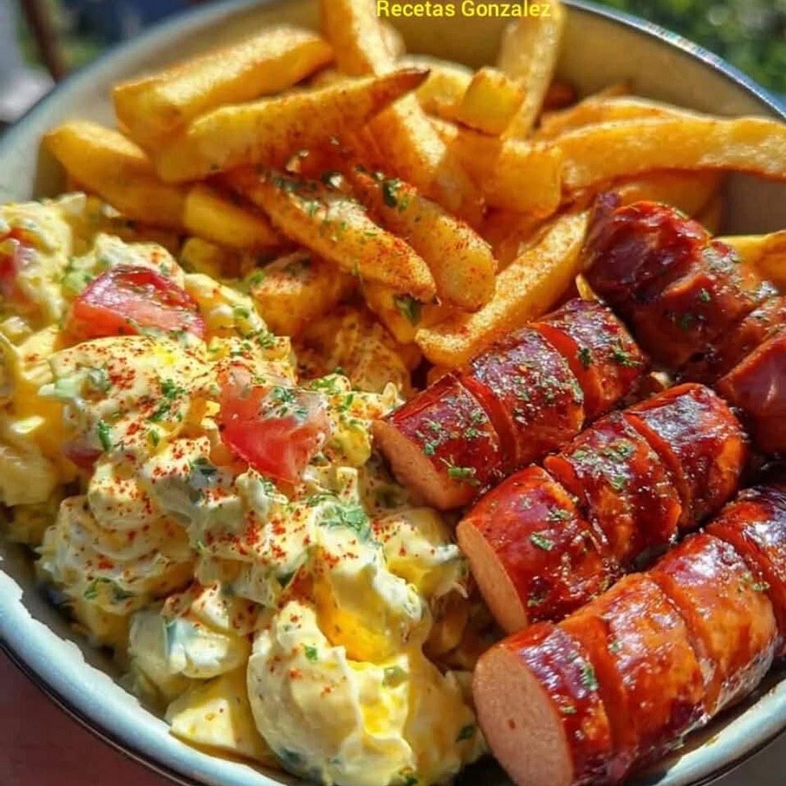 Papas fritas con salchicha rusa y ensalada cremosa de huevo.
