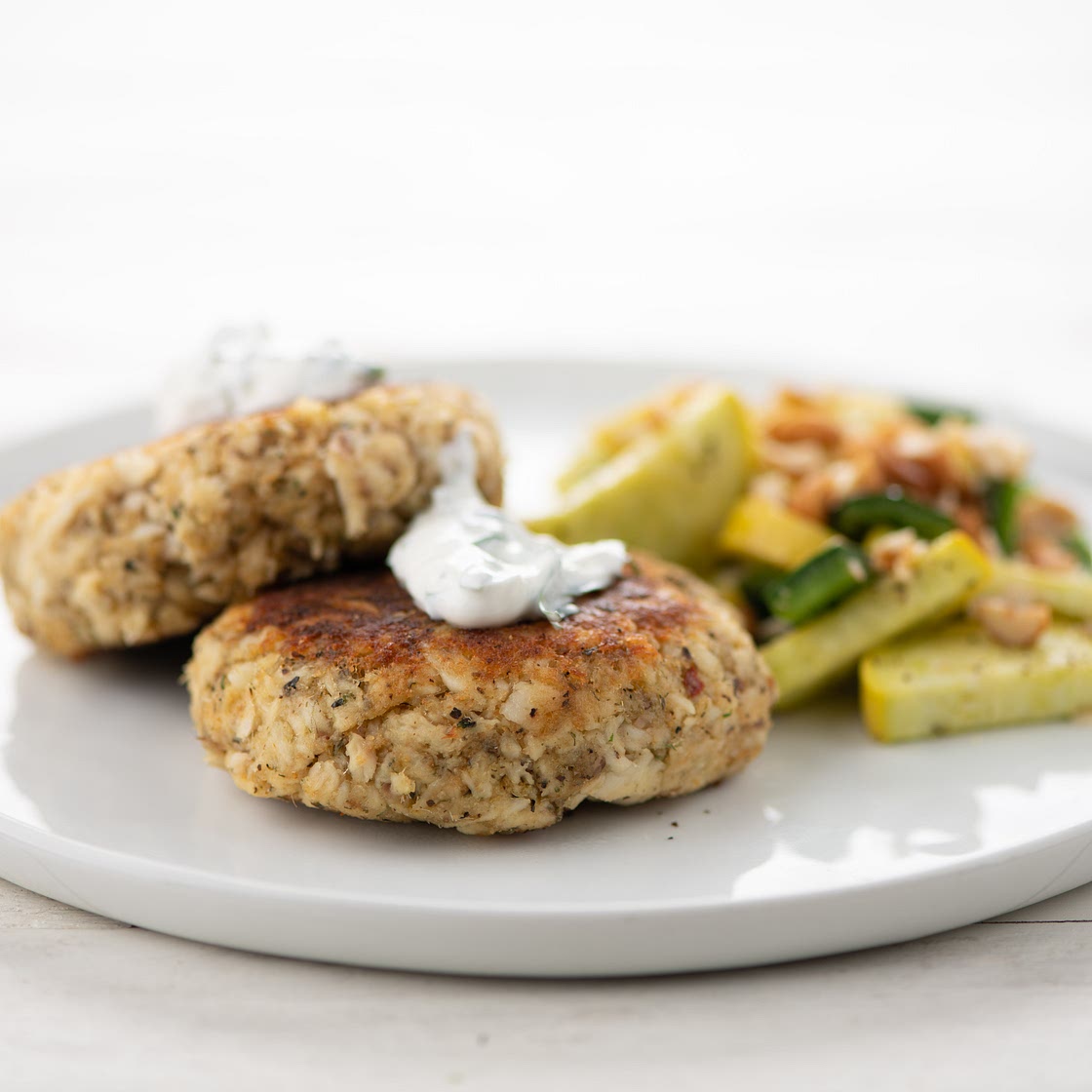 Spicy Argentinian Fish Cakes with cilantro crema, roasted poblanos, and summer squash