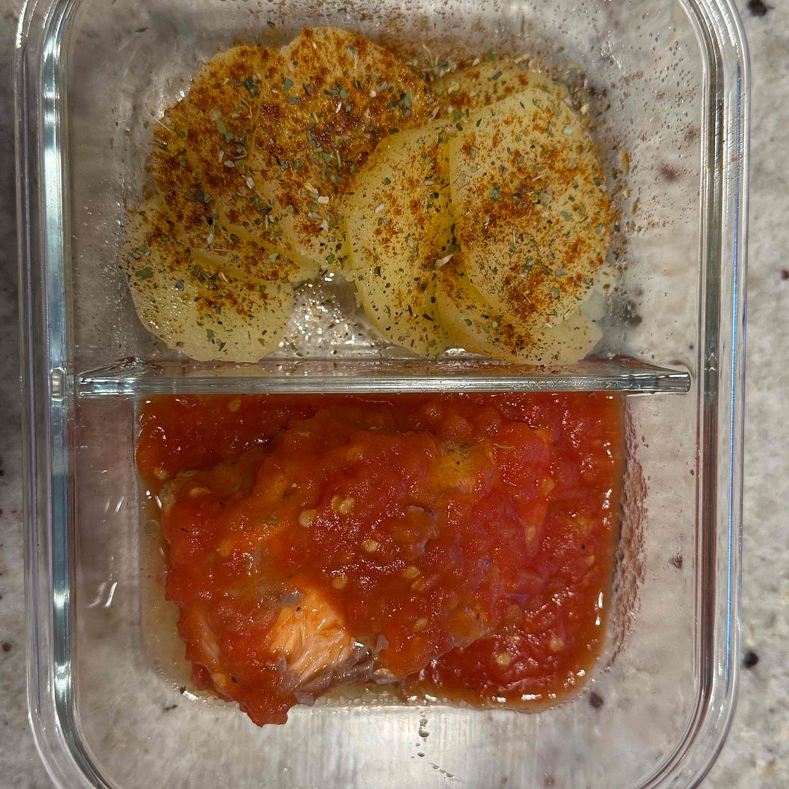 Troat in tomato sauce served with potatos.