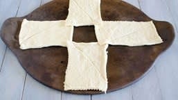 Separate 1 can of dough into 4 rectangles. On ungreased large cookie sheet, arrange rectangles perpendicular to each other to form a cross. Corners of one side should touch while leaving a square space in the center.