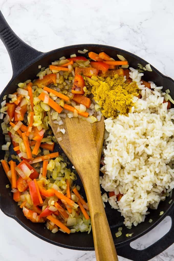 Anschließend den gekochten Reis, das Currypulver und die Sojasauce unterheben.