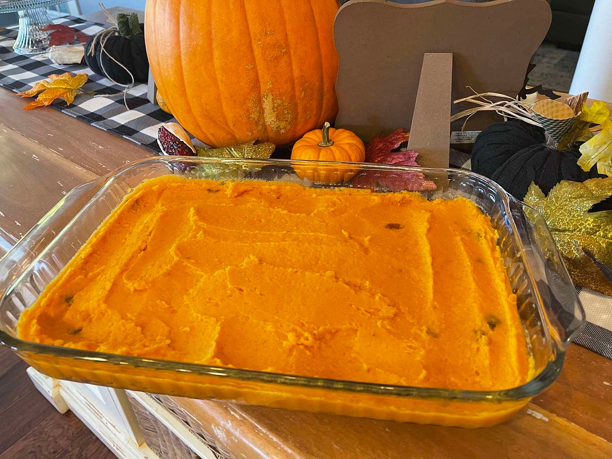 Drain yams into a mixing bowl. Add butter, brown sugar, salt and white pepper to the yams. Begin mixing the yams using a spatula adding enough hot milk until the mixture is moistened. Continue whipping the yams until fluffy. Fold in the white raisins. Place raisin and yam mixture into a shallow buttered casserole dish.
