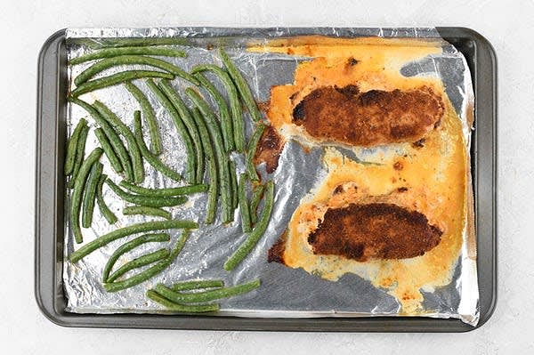 Bake the Chicken and Green Beans
Lay chicken away from you in hot oil and cook until beginning to brown, 2-4 minutes per side. Transfer chicken to prepared baking sheet and place evenly apart, seam side down. Wipe pan clean and reserve. Add green beans to empty side of baking sheet and top with 1 tsp. olive oil and a pinch of salt and pepper. Spread into a single layer. Bake in hot oven until green beans are bright green and chicken reaches a minimum internal temperature of 165 degrees, 12-15 minutes. While chicken and green beans bake, make sauce