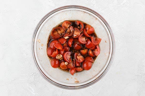 Make the Tomato Relish
In a mixing bowl, combine sugar, tomatoes, balsamic vinegar, feta, a pinch of salt, and 2 tsp. olive oil. Set aside to marinate, at least 10 minutes. While tomatoes marinate, make tzatziki.