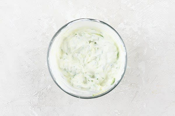 Make the Tzatziki
Combine remaining garlic (to taste), crème fraîche, grated cucumber, 2 tsp. water, and a pinch of salt in another mixing bowl. Set aside.