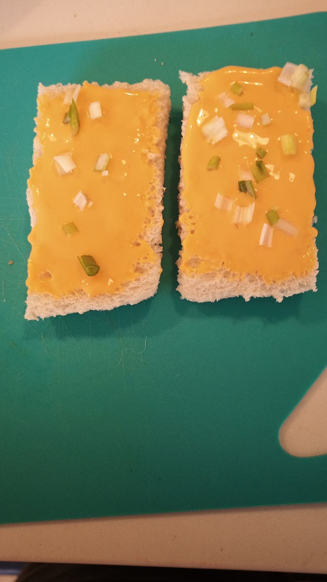 Beurrer le pain avec du Cheez-Whiz ( Le petit crèmeux Boivin) et saupoudré les ciboulettes au goût.