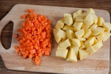Peel 4 medium-size potatoes and cut them into pieces. Peel one carrot and cut it into small cubes.