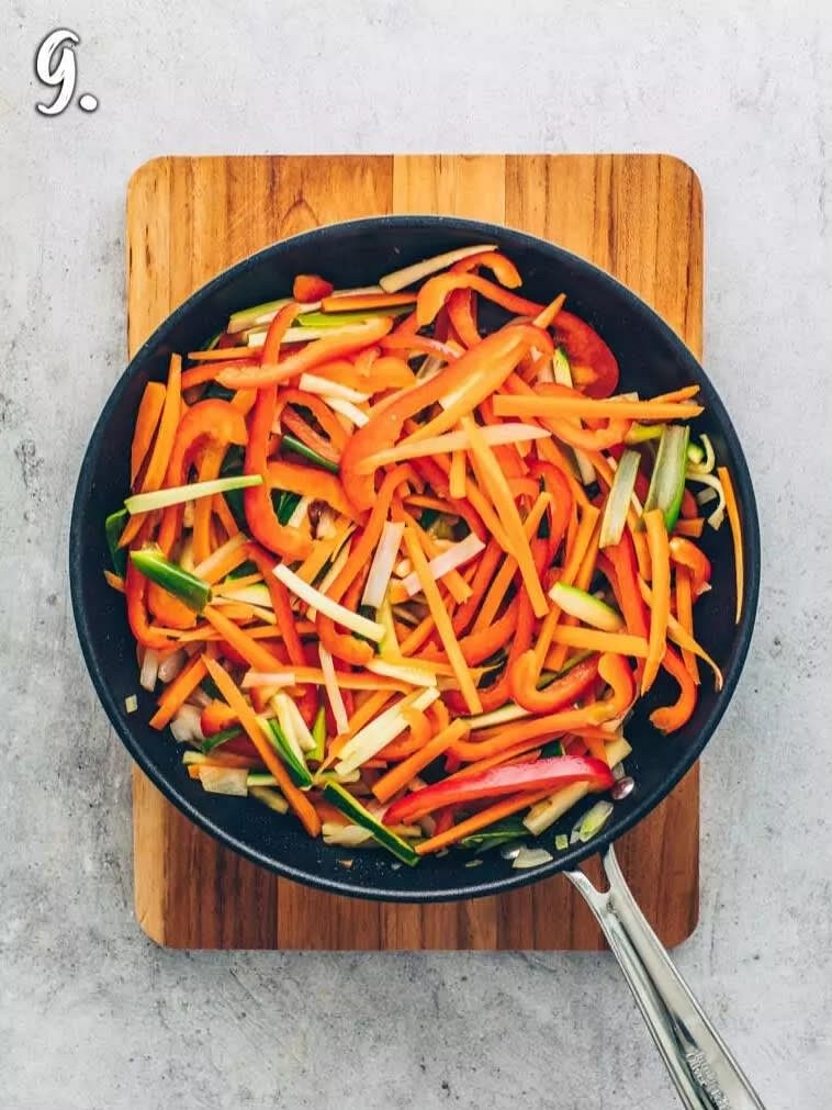 Dann Zucchini, Möhren und Paprika hinzugeben und einige Minuten weiter braten, bis das Gemüse gegart aber noch leicht knackig ist.