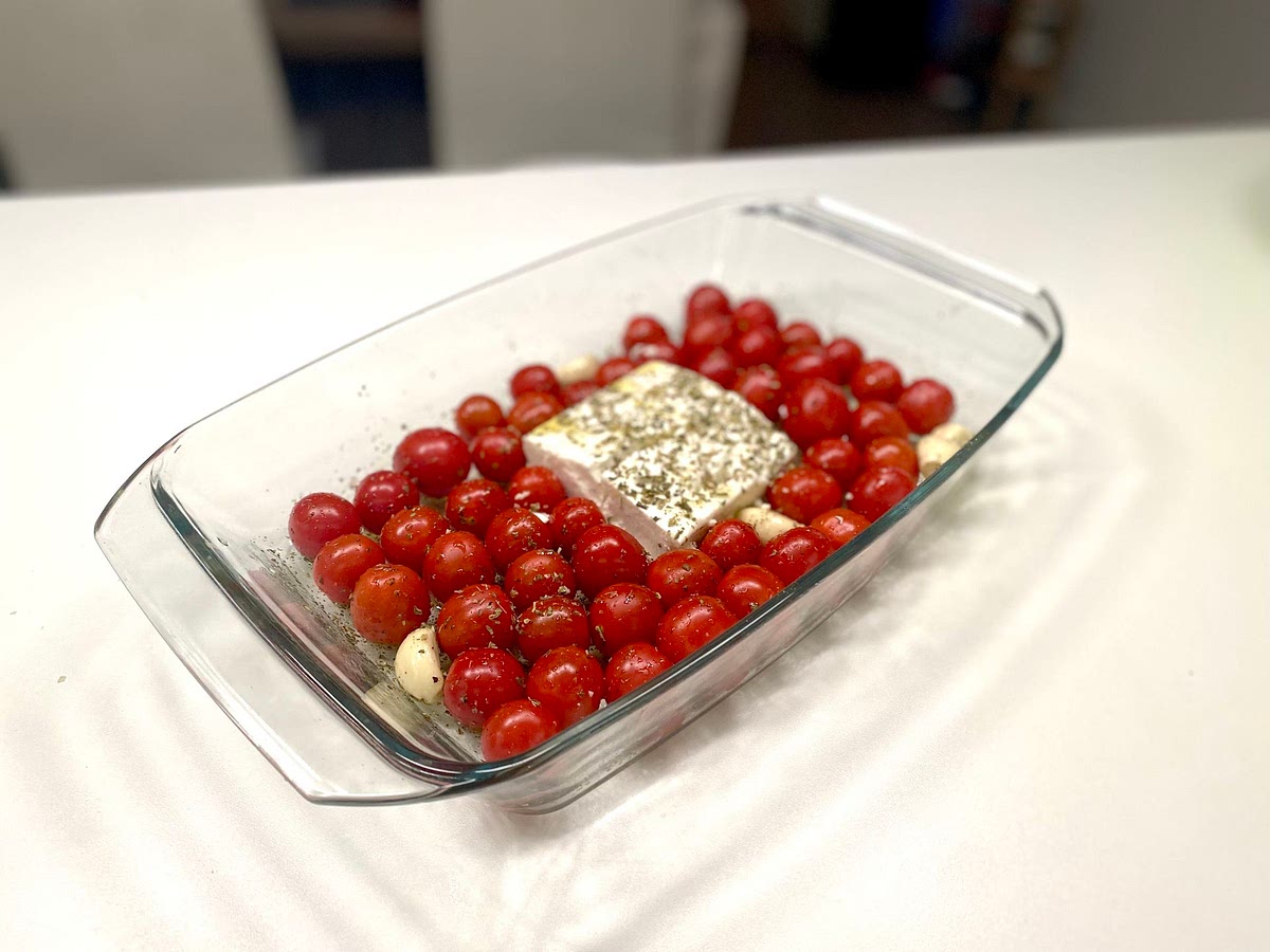 Place the block of feta cheese in the middle of the dish and place all the tomatoes around it. Add a sprinkle more of oregano and a drizzle of olive oil to the feta before placing into the oven.