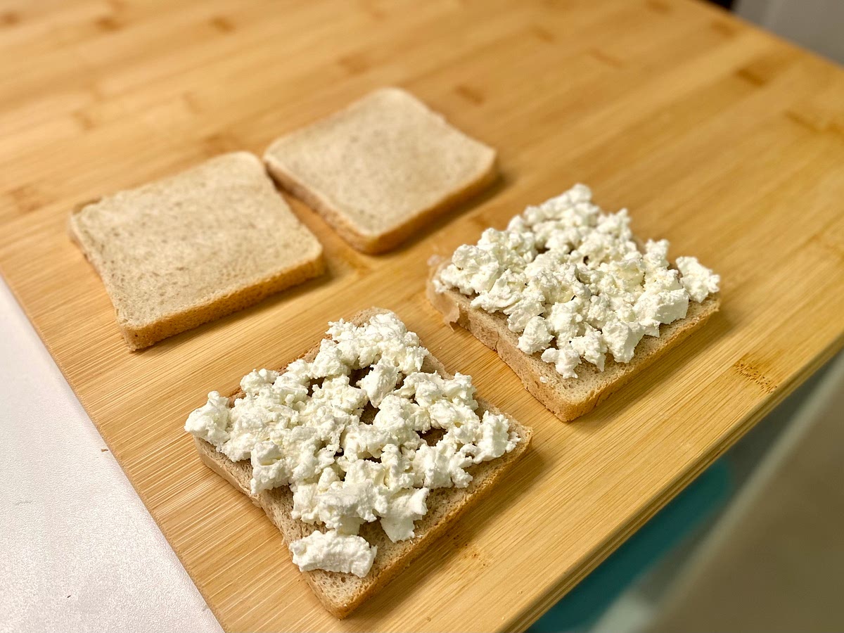Place the bread slices on a clean, dry work surface. Divide the cheese between 2 of the bread slices.