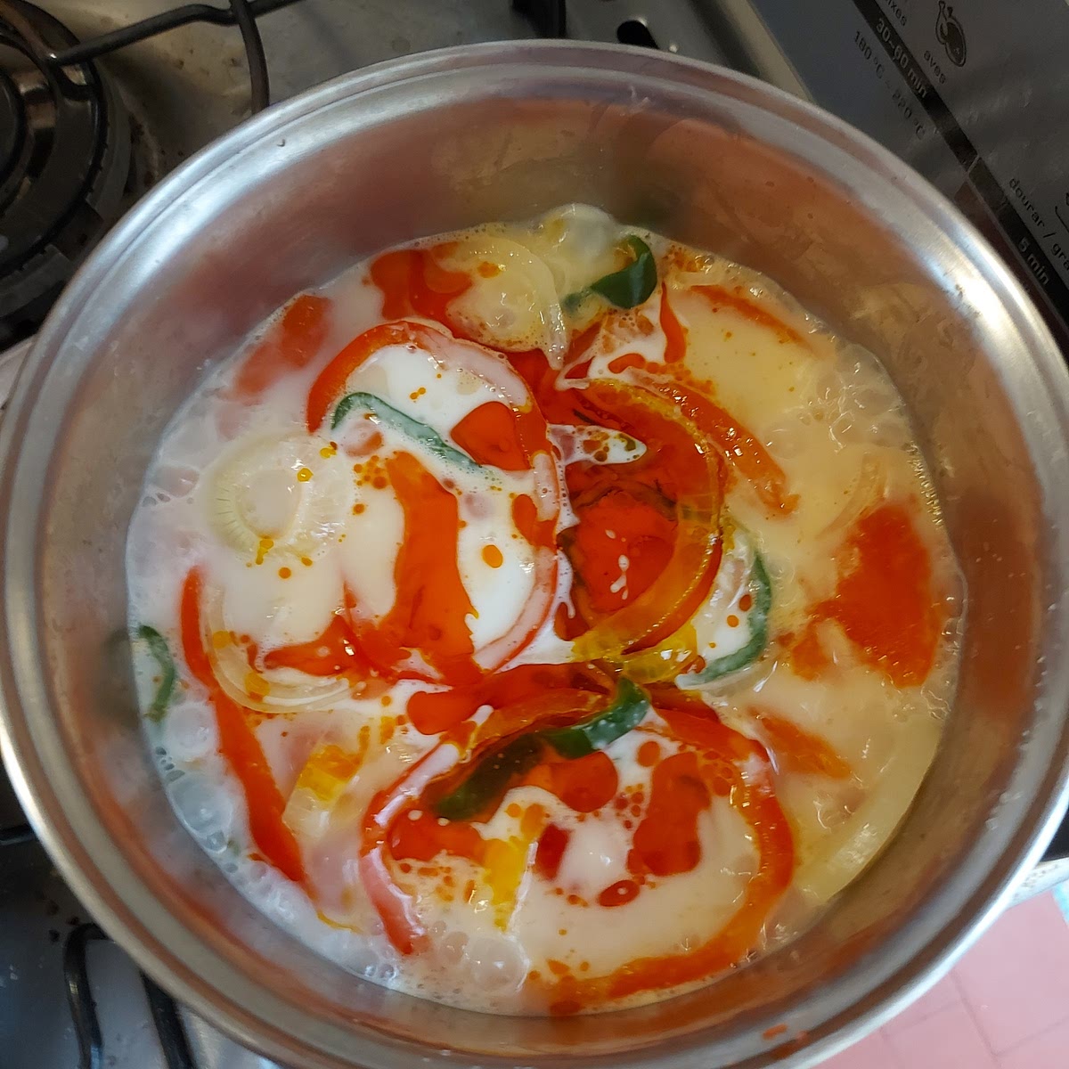 Adicione leite de coco e azeite de dendê à panela e mexa