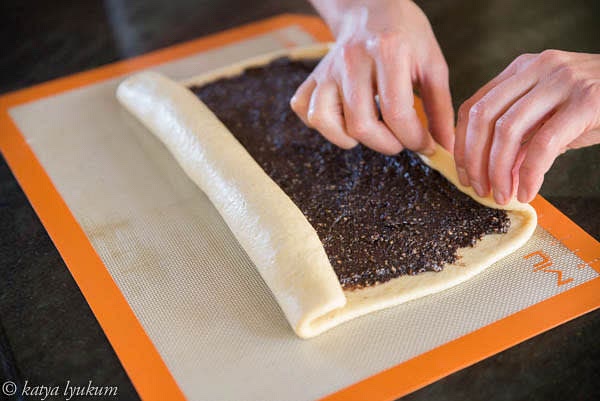 Roll two sides towards the center.