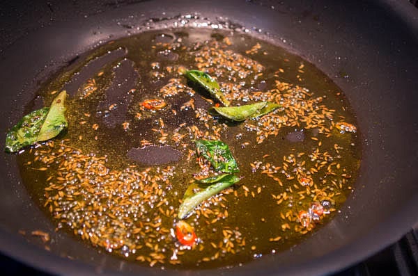 To make tarka, in a large skillet, heat the oil till smoking hot and reduce the heat to medium. Add mustard and cumin seeds. Cook till mustard seeds start popping. Add onions, garlic, and ginger and cook for another 30 sec, stirring. Add turmeric and curry leaves, and cook for another 10 sec, stirring.