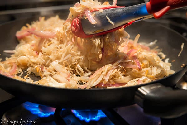 Slice onions. Squeeze cabbage to remove extra moisture. Heat 1 tbsp of oil in a skillet over high heat and saute onions and cabbage. Your goal is to evaporate some water and slightly caramelize vegetables.