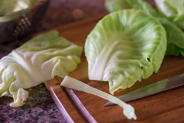 Trim thick center ribs on each leaf. Reserve small cabbage leaves and finely chop them for the stuffing.