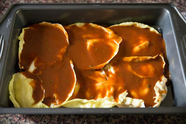 Preheat oven to 350F. Line a deep baking dish with small cabbage leaves. Pour half of the sauce to cover them.