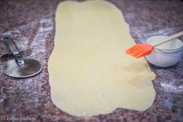 Roll it 1/16" or thinner. Brush with melted clarified butter. If you want your brioche sweeter, sprinkle the dough with sugar now. Otherwise, do it after the second layer or after the third, right before making a roll.