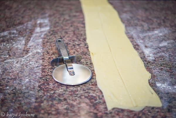 Use a rolling cutter to cut in the center and place one half on another, as shown in the picture. Repeat to make 4 layers of dough.