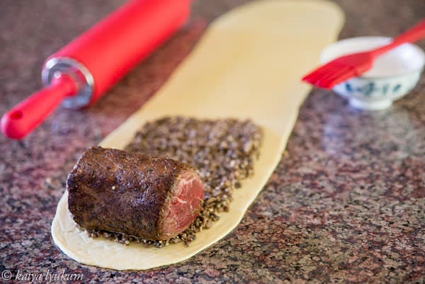 On the dough, spread pre-cooked mushrooms 0.2" thick to cover the area that will go around the tenderloin. Brush the rest of the dough with melted butter.