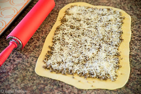 Stretch the dough and spread mushrooms 0.2" thick, leaving an uncovered border about 1" wide. Sprinkle with cheese.