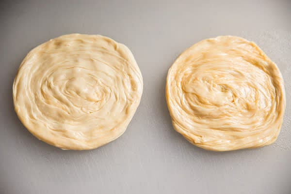 Flatten each portion of dough to make rounds ~4"D. Start with the dough you folded and rolled first. Let rounds rest for 5 minutes, covered.