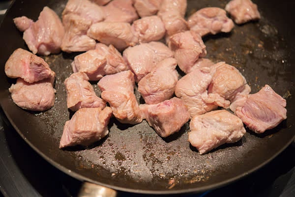 Heat oil or pork fat in a heavy skillet on high heat. Cook every batch separately for about 1 minute, constantly stirring, until the pork surface becomes white.