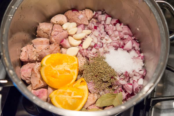 Peel and thinly slice onion. Peel garlic. Slice orange, discard seeds. Add them and the rest of the ingredients to the pot.