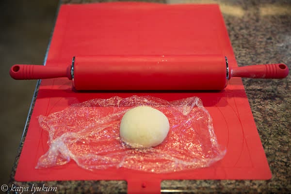 In a bowl, sift measured bread flour. Dissolve salt in lukewarm water, add lemon juice and 1 tbsp (reserve the second tbsp of butter for brushing stretched dough later) melted clarified butter, and combine with bread flour. Knead the dough for about 10 minutes to develop gluten well. Shape it into a ball and wrap it with plastic wrap. Keep for 1 hour at room temperature or refrigerated for 3 days.