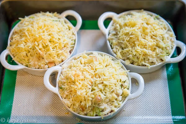 Top each ramekin with ~1.5oz of shredded cheese. Place ramekins into a baking pan lined with a silicone pad to prevent sliding.
