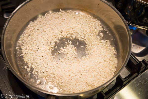 Add rice to the onions and cook briefly until rice grains are semi-transparent and hot to the touch. Do not let it caramelize. Add white wine, stir, and let the wine evaporate.