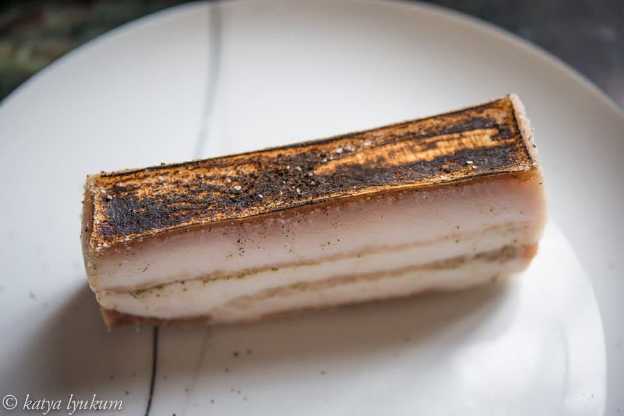 Blacken the pigskin with a torch. Wet it with hot water and scrape the charred part away. Repeat 2-3 times.