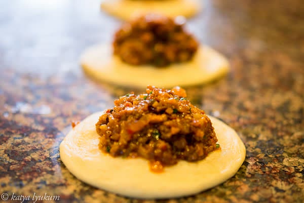 Divide the dough into 8 portions (52g each). Shape them into balls and let rest for 10-15 minutes, covered. Flatten each into 4" D disks, thicker in the center, thinner on the edges. Place 3-4 tbsp of pork filling in the center of each disk and shape buns.