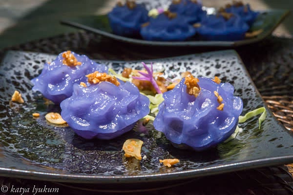 To serve, arrange green leafy vegetables and hot steamed dumplings on the plate and top them with crispy and sweet caramelized garlic.