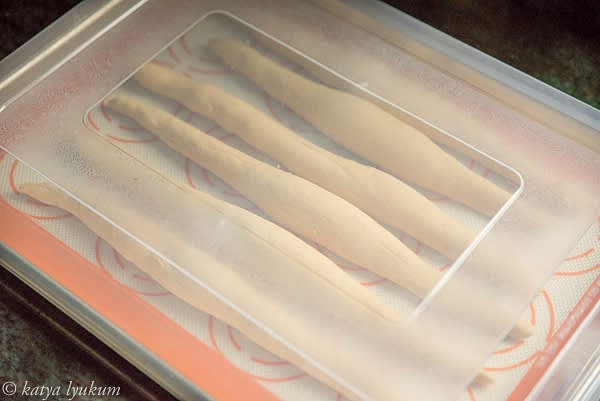 Shape each portion of the dough into a cylinder 12-13" long, 1" in diameter, thinning toward the ends. Cover and let them rest for 20 minutes. NOTE: To shape pretzels, do not dust your working surface with flour. Instead, dampen the table or your hands to generate some friction for successful rolling.