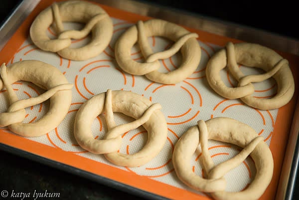 Roll each portion of the dough 28-30" long with a thicker belly and thin ends and make a knot. Let shaped pretzels rest UNCOVERED in the fridge for about an hour. They will form a thin outer layer to absorb dipping lye solution better and make a shiny golden-brown crust.