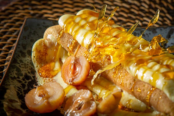 In a saute pan, combine sugar and a small amount of water (e.g., 1 tsp of water for 6 tbsp of sugar) and melt sugar into a golden caramel. Let it cool for a moment and drizzle over the plated crepes. Drizzle the leftovers of caramel on a silicone mat, let it cool, break into pieces and use them for decor.