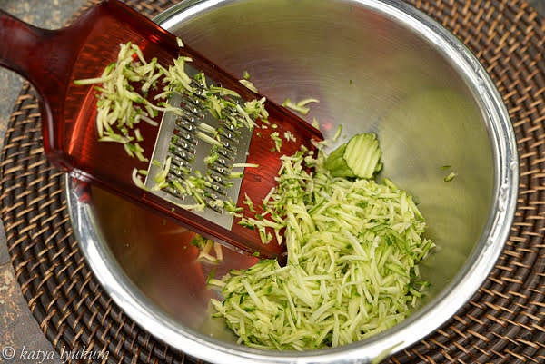 Rinse zucchini and grate it.