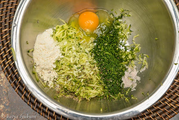 Finely chop fennel greens and green garlic. In a small bowl, place — but do not mix yet! — all the ingredients for the stuffing — grated zucchini, finely chopped garlic, fennel, egg, flour, salt, and freshly ground black pepper. You want the salt to contact your grated vegetables as close to when you are ready to cook them as possible. Otherwise, the salt will draw the water from the vegetables, and the mix will become watery.