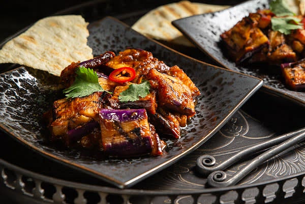 Transfer the sauce into a saute pan and place it over low heat. Bring to simmer, stirring. Let cook for 2-3 minutes. Add eggplants and gently stir to coat all pieces with the sauce. Cover with a lid and let slowly cook for another 10 minutes. Enjoy with crispy grilled flatbread.