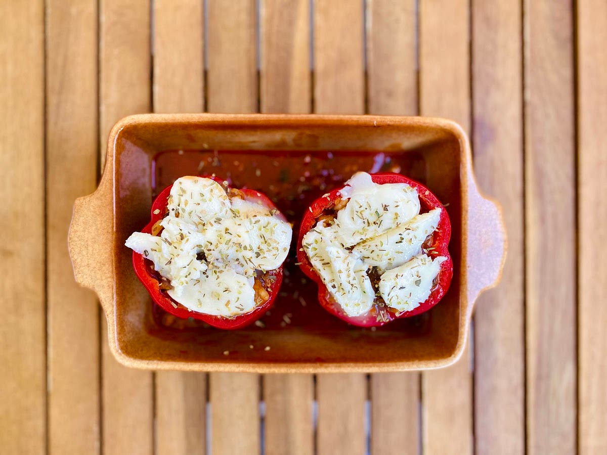 Fill each bell pepper with vegetable mixture, making sure to pack it well. Optionally, sprinkle with mozzarella or vegan shredded cheese. Pour the remaining tomato pure (150 ml) in, around the peppers. Cover with lid or tin foil.