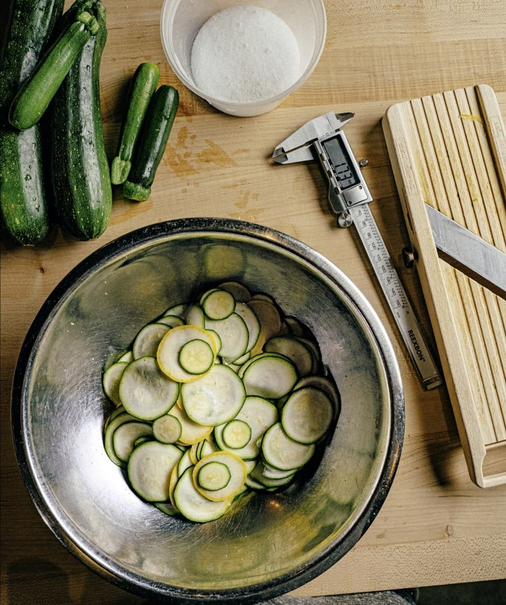 Weigh the zucchini and combine with 0.75 percent salt by weight in a medium bowl. Set aside, covered, in the refrigerator overnight. Drain and squeeze off any excess water, then drizzle with olive oil.