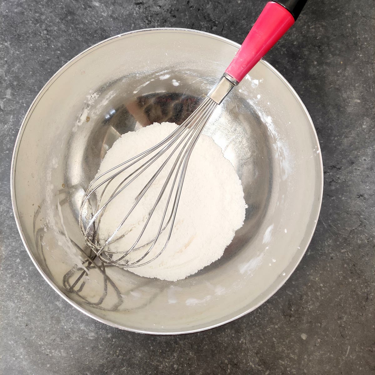 Dans un plat, mélanger la farine au sucre avec un fouet