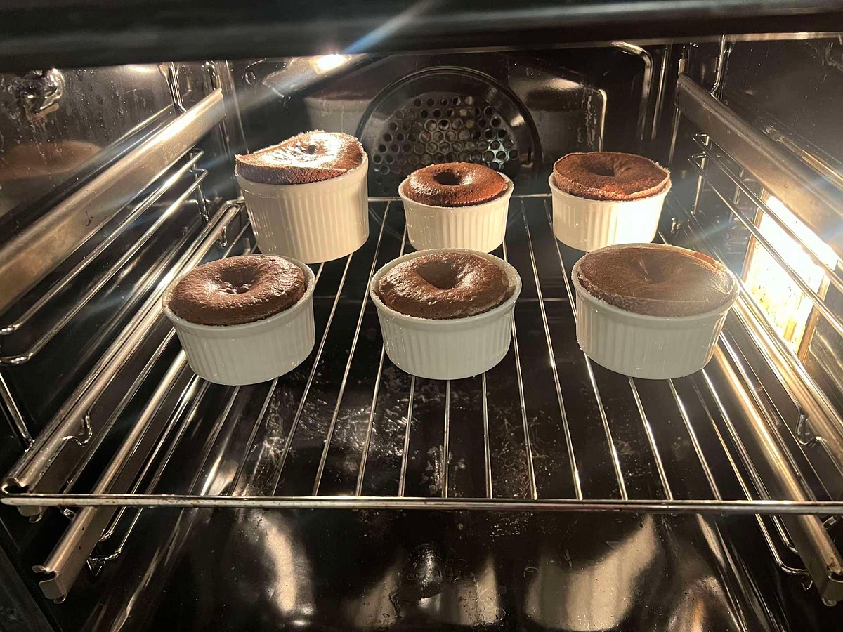 Bake for 8 - 14 minutes depending on your oven and the size of your ramekins. After the 8 minute mark, watch your lava cakes like a hawk, they change very quickly from the stage where they will make a chocolatey puddle on your plate to the stage where they are overbaked and won't ooze properly. You'll know they are ready when the outside looks baked and is pulling away from the edges slightly, but the middle still looks like there is a puddle of wet chocolate in there - if you shake the ramekins, it should wobble but it will all wobble together as a whole, rather than glooping around the ramekin - that's when they are ready!
