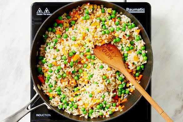 Add the rice, peas and 2 tsp soy sauce to the vegetables and cook, stirring, for 30 secs or until well combined and heated through. Divide the rice and salmon among bowls and drizzle with the pan juices to serve.
