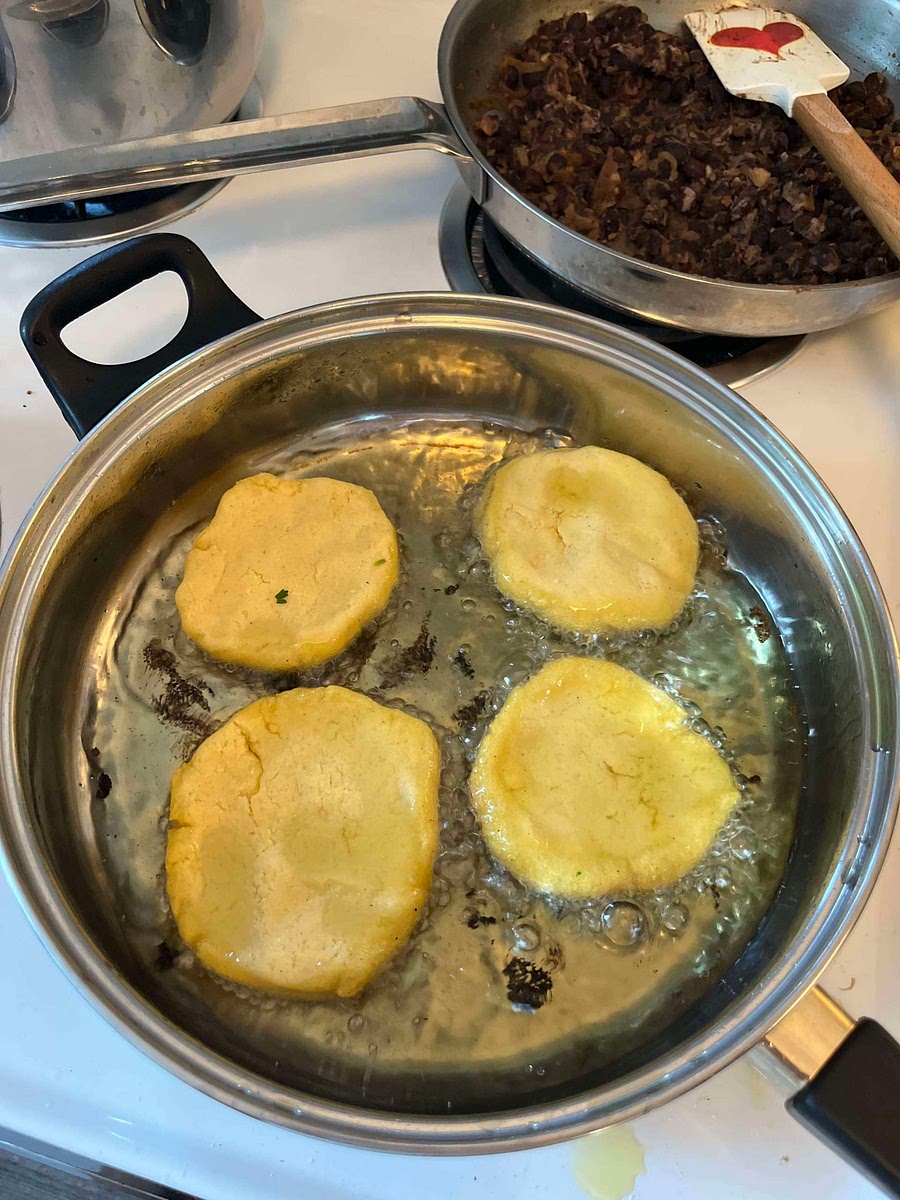 Heat a thin layer of oil (about 1/4 inch deep) in a large heavy skillet over medium heat. Add the arepas and fry for about 6 minutes on both sides. The arepas should get a dry fried exterior without getting overly brown. Set on paper towels to drain and cool
